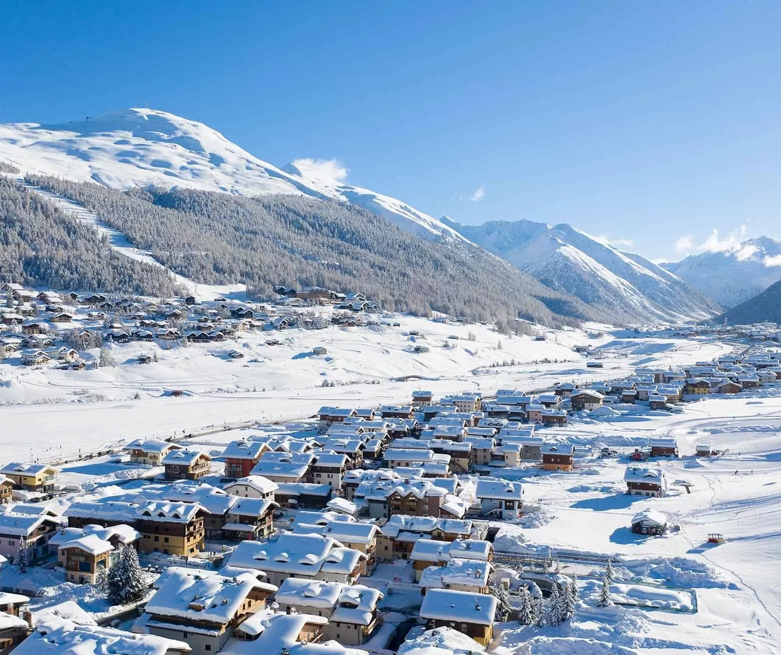 Snowy mountain village under clear blue sky.
