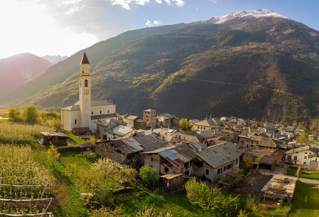 Mountain village with church and surrounding landscape.