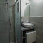 Small modern bathroom with glass shower door.