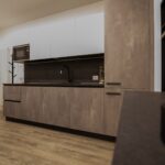 Modern kitchen with wooden cabinets and flooring.