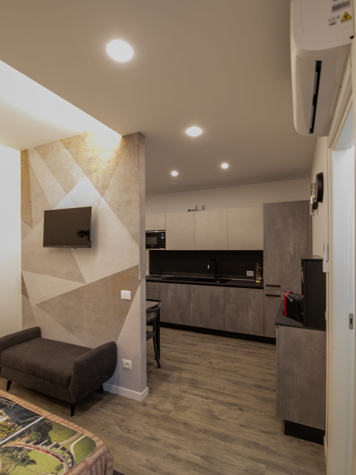 Modern studio apartment with kitchen and sofa.