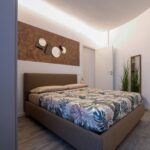 Modern bedroom with patterned bedspread and decor.