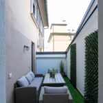 Narrow patio with outdoor seating and plants.