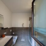 Modern bathroom with shower and large window.