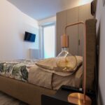 Modern bedroom with stylish lamp and TV.