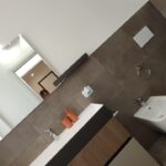 Modern bathroom with brown tiles and fixtures.