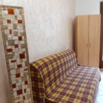 Plaid sofa and wooden wardrobe in room.