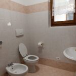 Bathroom with toilet, bidet, and sink.