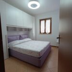 Modern bedroom with double bed and window.