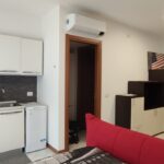 Modern kitchen and living area with sofa.