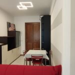 Small dining area with red sofa.