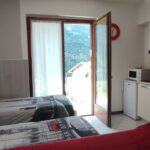 Small apartment with twin beds and kitchenette.