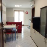 Modern living room with red sofa and table.