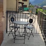 Balcony with table, chairs, mountain view.