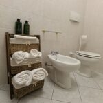 Bathroom with towels and toiletries on shelf.