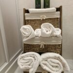 Rolled towels on wicker bathroom shelf.